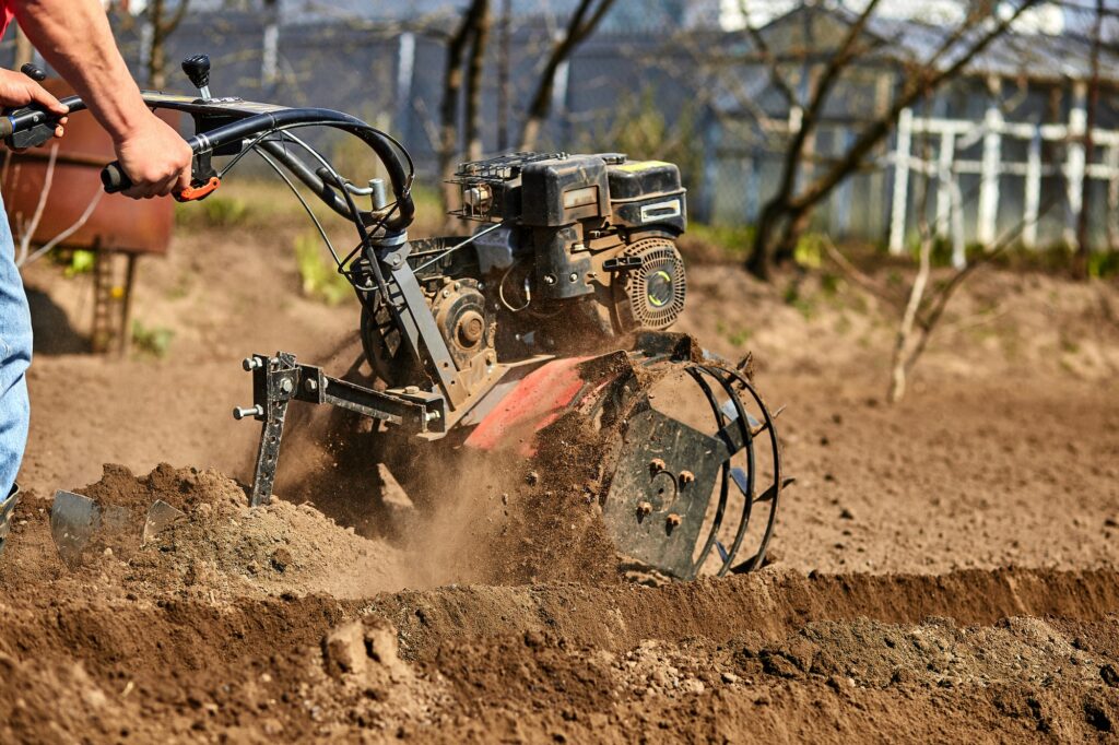 Man working in the garden with Garden Tiller.