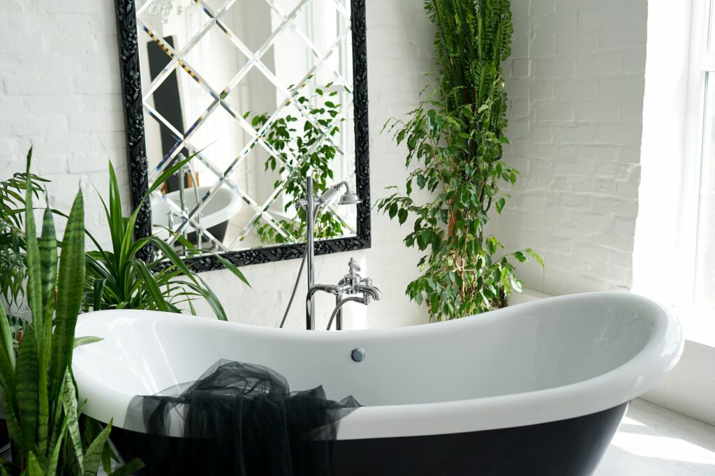 Bathtub and green plants in bathroom interior in luxury home