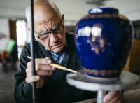 Senior man decorating ceramic vase in his spare time