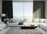 White corner sofa in luxury living guest room with black curtains and window on background